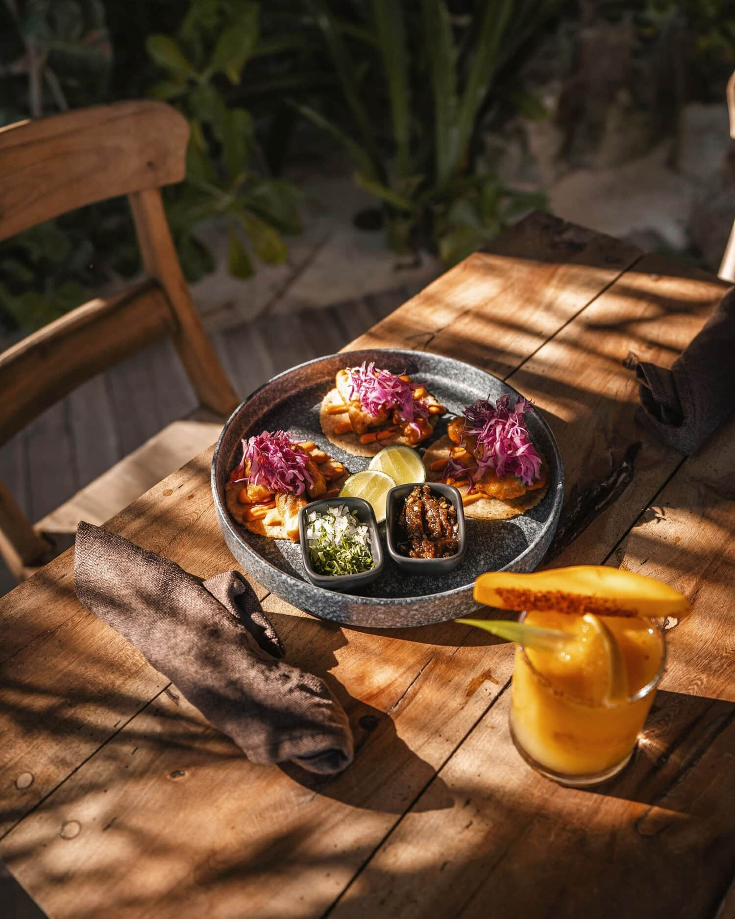 Plato con tacos y una bebida de mango en el restaurante de Encantada Tulum 